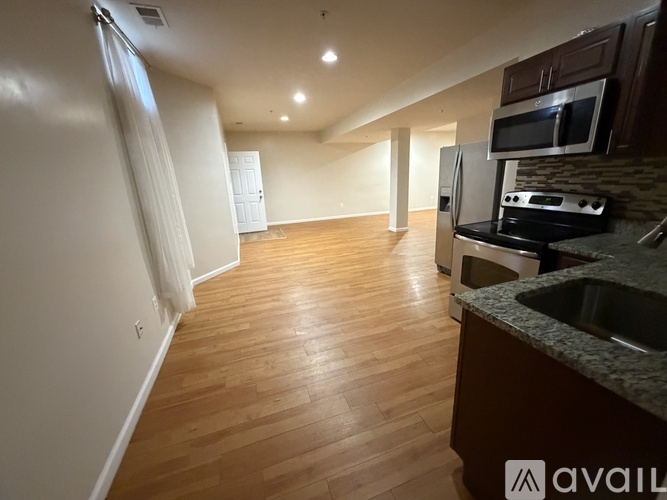 A kitchen with a sink, stove, and microwave.