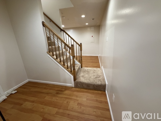 A wooden staircase with a beige carpeted landing.