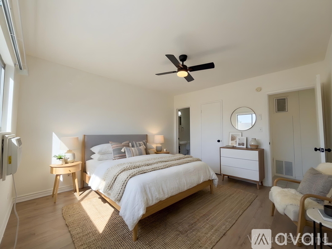 A bedroom with a large bed and a ceiling fan.