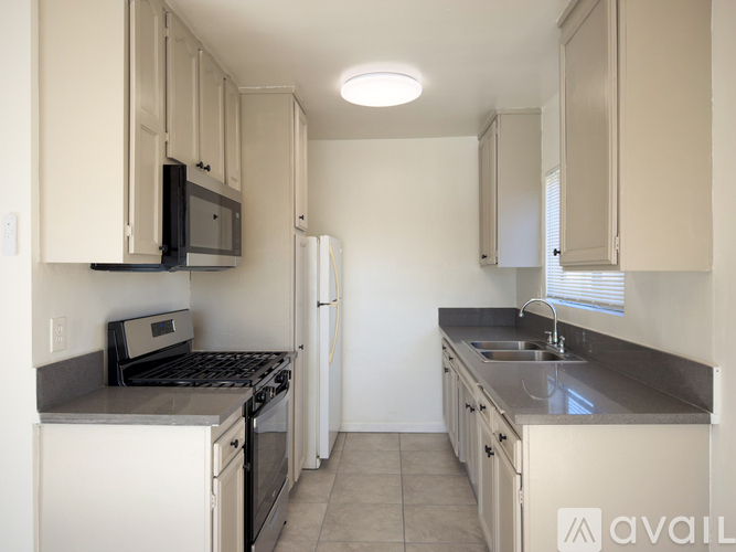 A kitchen with white cabinets and appliances.