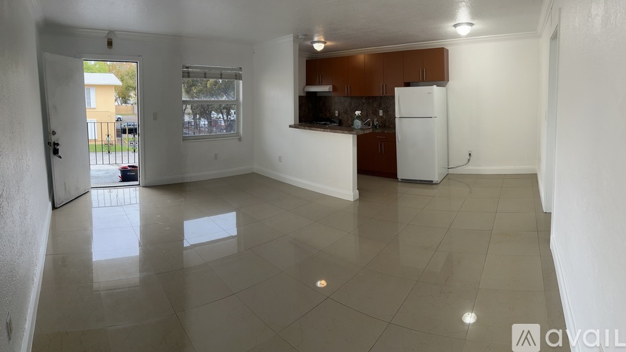 A kitchen area with a refrigerator, sink, and cabinets.