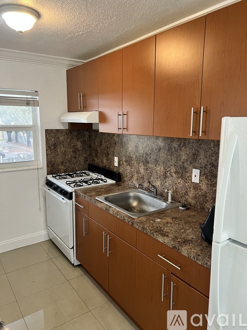 A kitchen with brown cabinets and a white fridge.