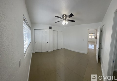 A spacious room with a ceiling fan and tiled floor.