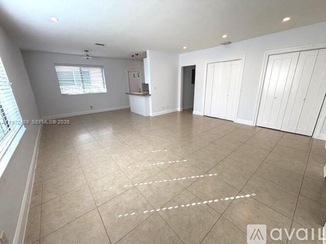 A spacious room with white walls and a tiled floor is available for rent.