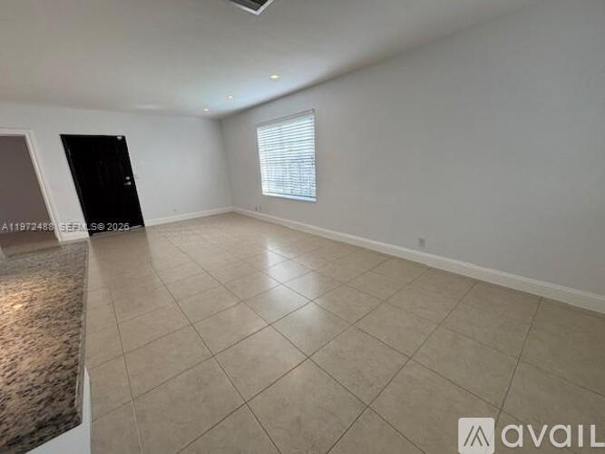 A room with a tiled floor and a window with blinds.
