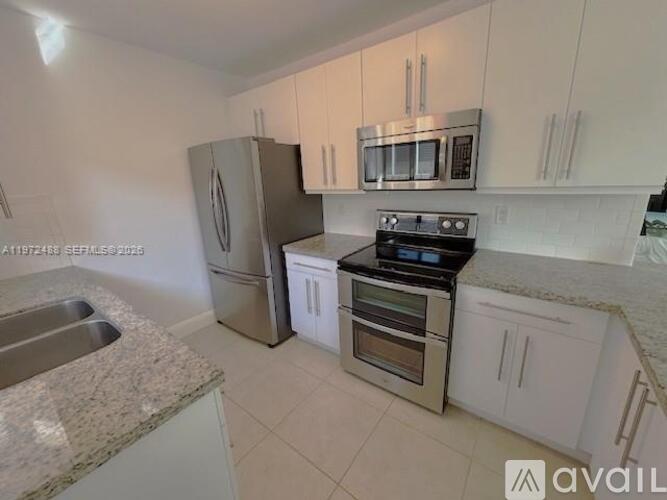 A kitchen with white cabinets and stainless steel appliances.