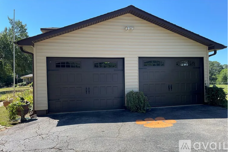 A two-car garage with a tan siding and a brown roof.