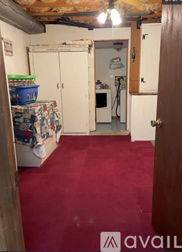 A kitchen area with a refrigerator, cabinets, and a sink.