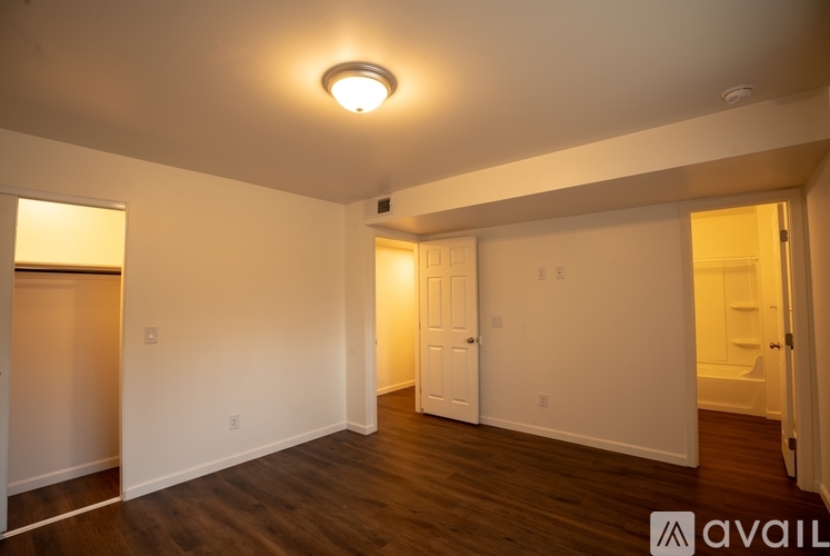 A spacious room with wooden floors and white walls.