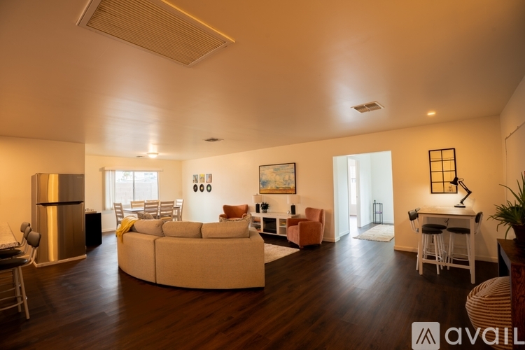 A living room with a white couch and a wooden floor.