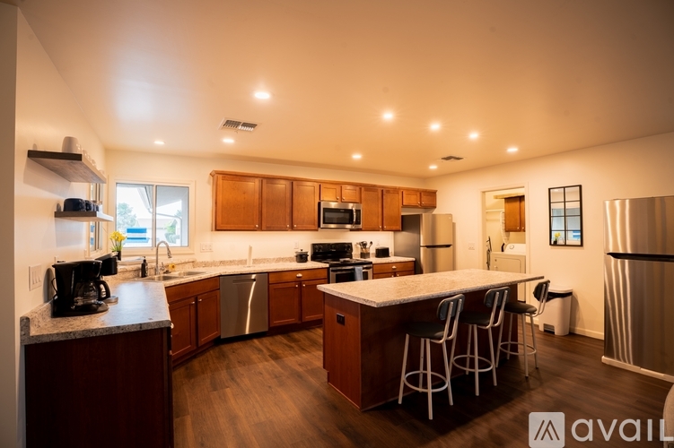 A modern kitchen with wooden cabinets and stainless steel appliances.