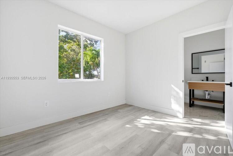 A room with a window and a wooden bench.