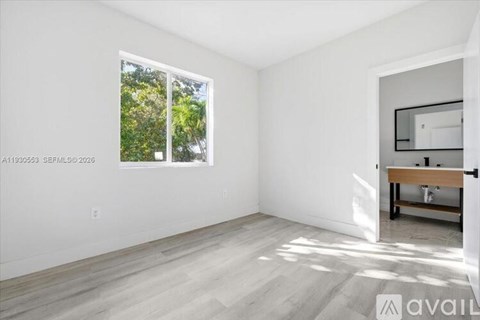A room with a window and a wooden bench.