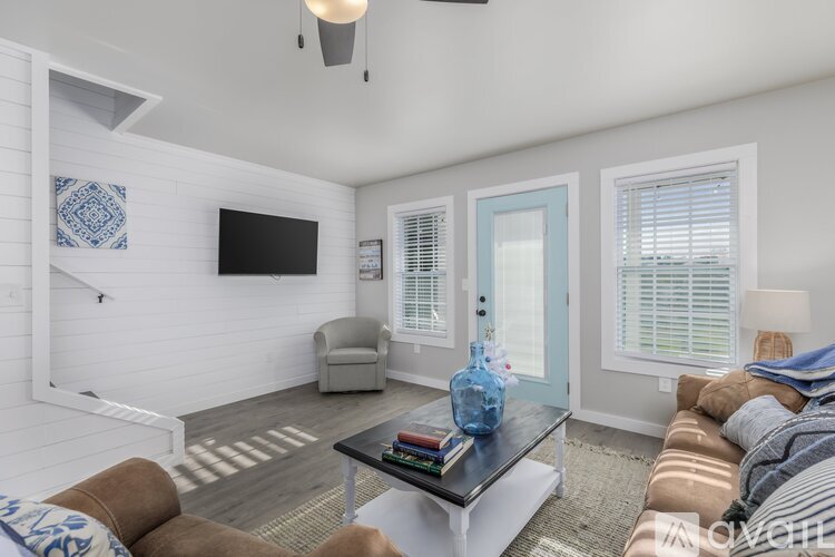 A living room with a brown couch and a blue vase on the coffee table.