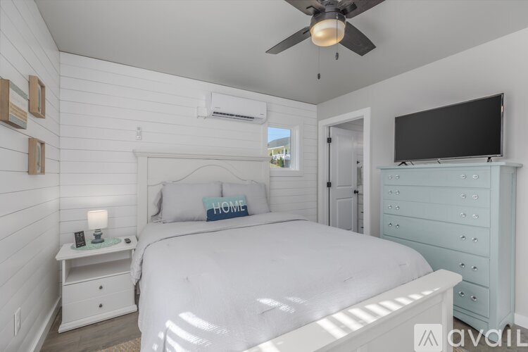 A bedroom with a bed, nightstand, and a television.