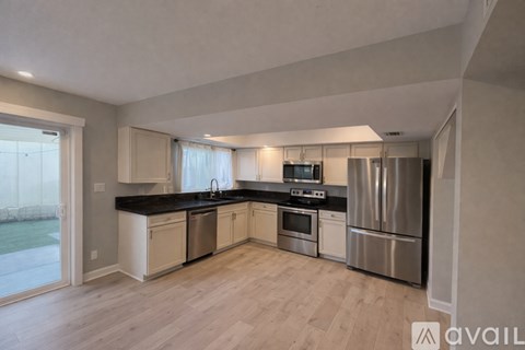 A kitchen with a refrigerator, sink, and stove.