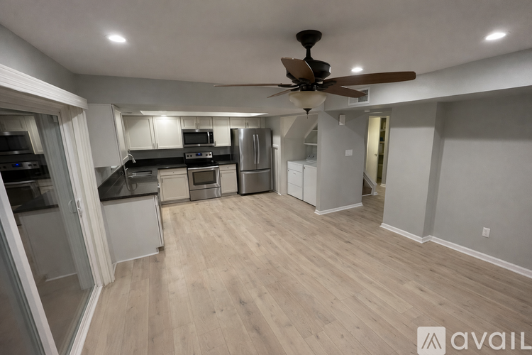 A spacious kitchen with a ceiling fan and lighting fixtures.
