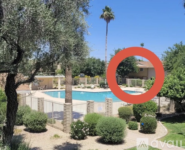 A pool surrounded by a fence and trees.