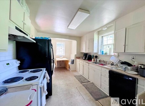 A kitchen with white appliances and cabinets.