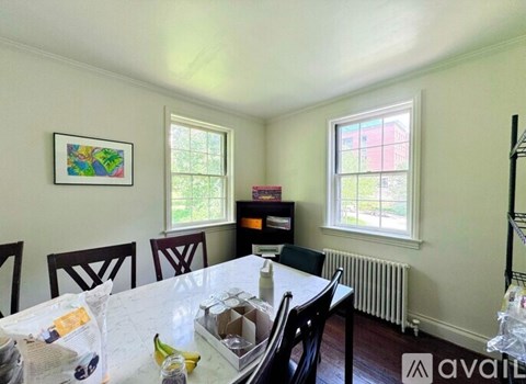 A dining room with a table, chairs, and a window.