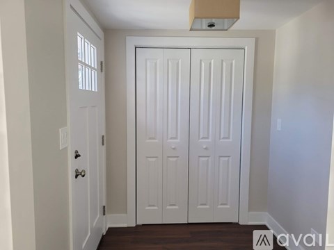 A white door with a handle and a window on the left.