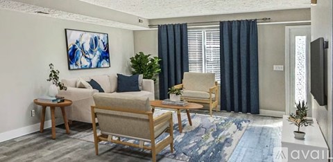 A living room with a couch, chairs, and a painting on the wall.