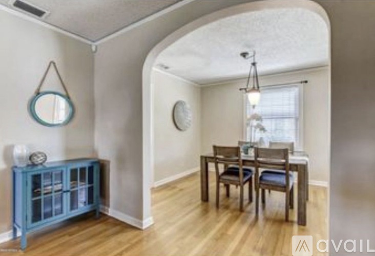 A dining room with a wooden table and chairs.
