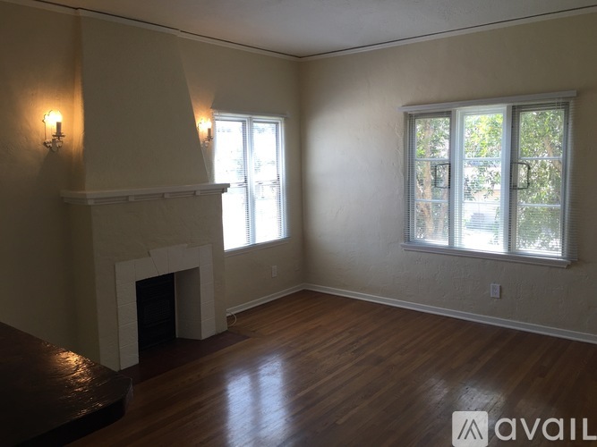 A living room with a fireplace and two windows.