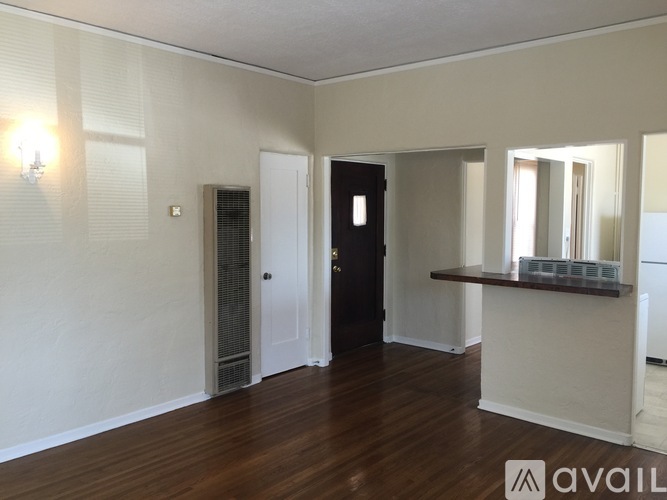 A room with wooden floors and a black door.