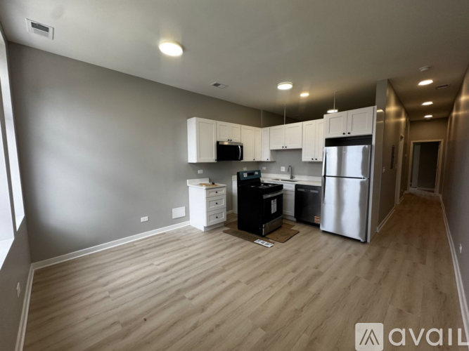 A kitchen with a refrigerator, microwave, and oven.