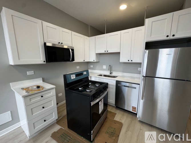 A kitchen with white cabinets and a black stove top oven.