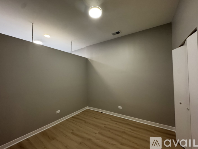 A room with wooden flooring and grey walls.