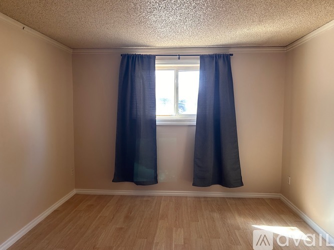A room with a window and curtains.