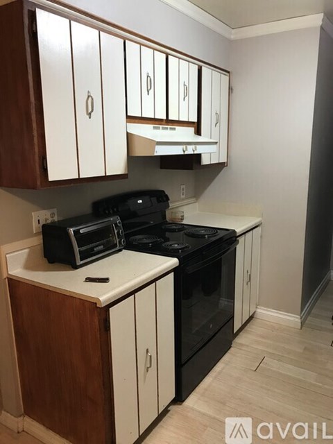 A kitchen with white cabinets and a black stove top oven.