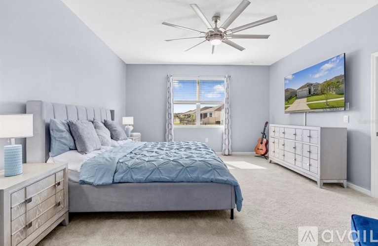 A bedroom with a large bed and a flat screen TV mounted on the wall.