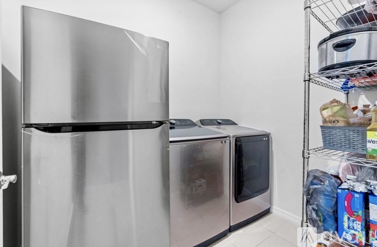 A kitchen with a stainless steel refrigerator and microwave.