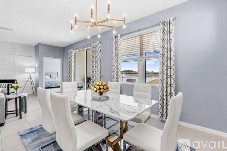 A dining room with a glass table and white chairs.