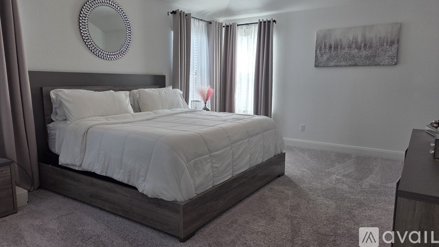 A bedroom with a large bed and a mirror on the wall.