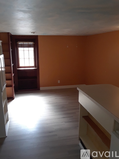 A room with orange walls and a window.