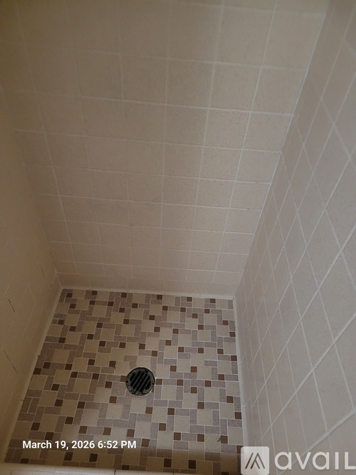 A bathroom with a tiled floor and walls.