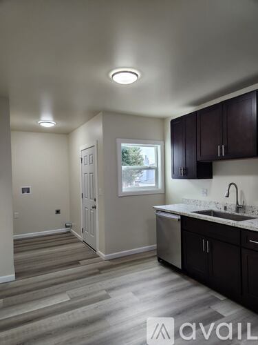 A kitchen with dark wood cabinets and a white counter top.