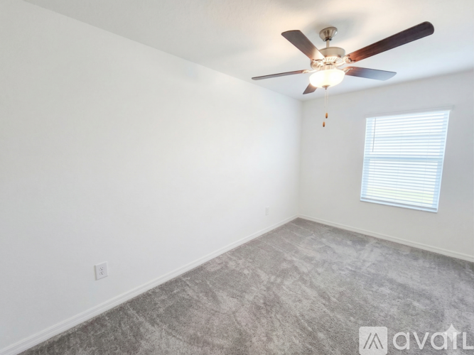 A bedroom with a bed, nightstand, and ceiling fan.