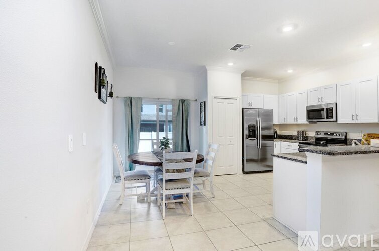 A kitchen with a table and chairs in front of a window.