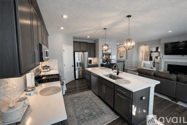 A modern kitchen with a large island and a fireplace in the living room.