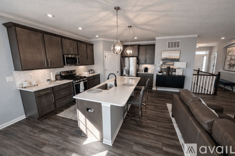 A modern kitchen with dark brown cabinets and a white island.