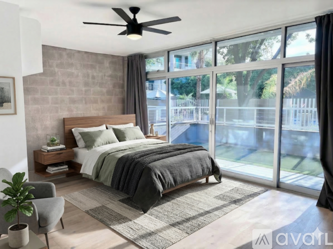 A bedroom with a large bed and a ceiling fan.
