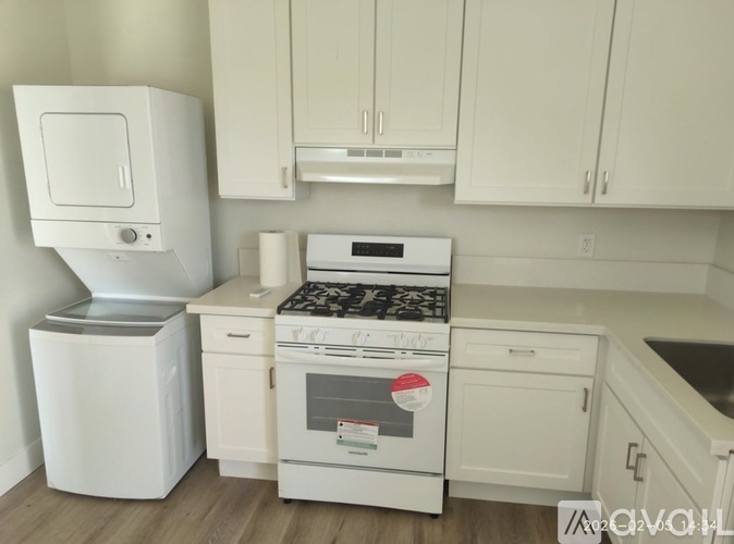 A white kitchen with a stove top oven and a white fridge.