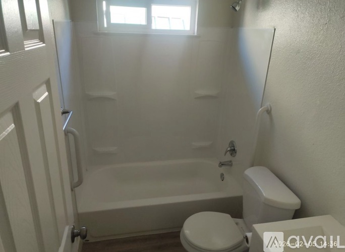 A white bathroom with a toilet, tub, and sink.