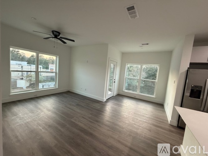 A spacious room with a ceiling fan and large windows.