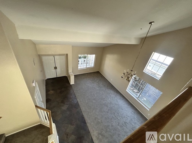 A room with a carpeted floor and a window with a view of a building outside.